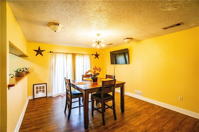 2404 Timbers Dr, Harvey, LA 70058 - dining room with a textured ceiling, dark wood-type flooring, a chandelier, and baseboards
