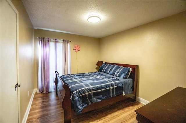 2404 Timbers Dr, Harvey, LA 70058 - bedroom featuring a textured ceiling, wood finished floors, and baseboards