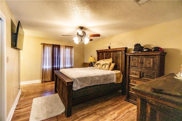 2404 Timbers Dr, Harvey, LA 70058 - bedroom with light wood-style floors, ceiling fan, baseboards, and a textured ceiling