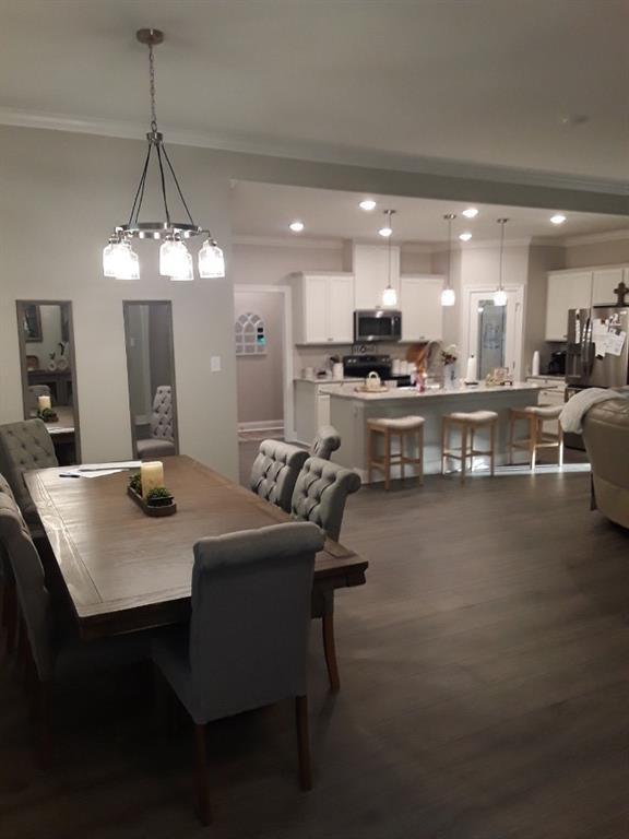 42155 Pasqua Rd, Ponchatoula, LA 70454 - dining space featuring crown molding, recessed lighting, dark wood-type flooring, and a chandelier