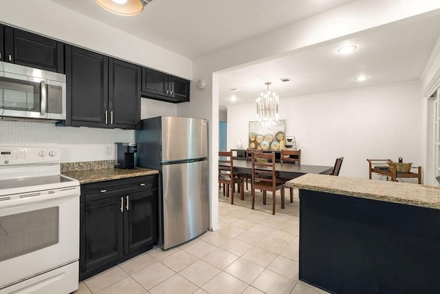71164 Clipper Pl, Abita Springs, LA 70420 - kitchen with stainless steel appliances, dark cabinetry, decorative backsplash, and recessed lighting