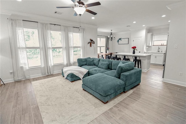 39593 Fly Creek Rd, Ponchatoula, LA 70454 - living area featuring ornamental molding, a ceiling fan, baseboards, light wood-type flooring, and a chandelier