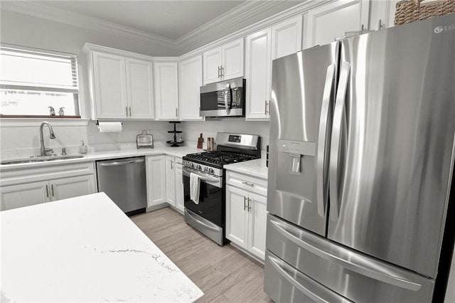 39593 Fly Creek Rd, Ponchatoula, LA 70454 - kitchen featuring appliances with stainless steel finishes, a sink, light countertops, white cabinetry, and ornamental molding