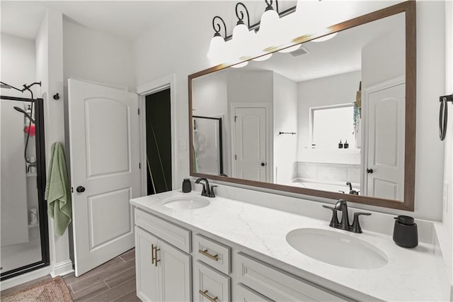 39593 Fly Creek Rd, Ponchatoula, LA 70454 - bathroom with a shower stall, double vanity, a bath, and wood finished floors