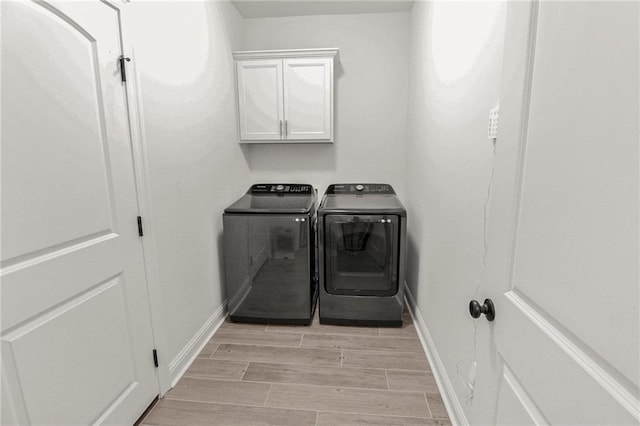 39593 Fly Creek Rd, Ponchatoula, LA 70454 - laundry area featuring washing machine and clothes dryer, cabinet space, baseboards, and light wood-type flooring