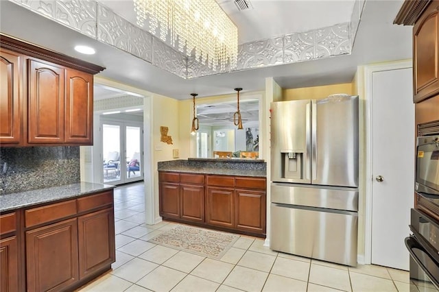 2442 Killdeer St, New Orleans, LA 70122 - kitchen with stainless steel fridge, oven, light tile patterned flooring, and backsplash