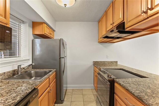 3805 Houma Blvd Unit C101, Metairie, LA 70006 - kitchen with stainless steel appliances, under cabinet range hood, a sink, baseboards, and light tile patterned floors