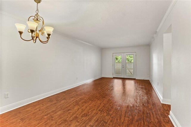 3805 Houma Blvd Unit C101, Metairie, LA 70006 - spare room featuring ornamental molding, a chandelier, wood finished floors, and baseboards