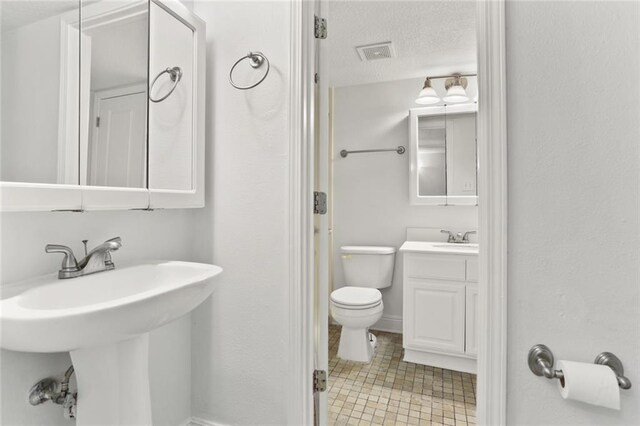 3805 Houma Blvd Unit C101, Metairie, LA 70006 - bathroom featuring a sink, toilet, tile patterned floors, and a textured ceiling