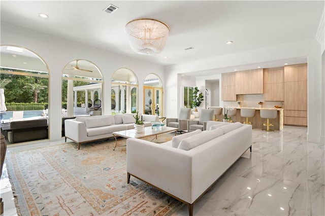 139 Fontainbleau Dr, Mandeville, LA 70471 - living area featuring light marble finish floors, recessed lighting, a chandelier, and crown molding