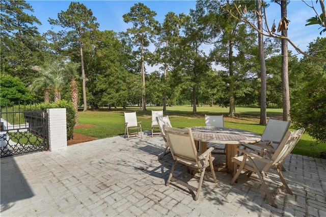 139 Fontainbleau Dr, Mandeville, LA 70471 - view of patio with view of wooded area and outdoor dining area