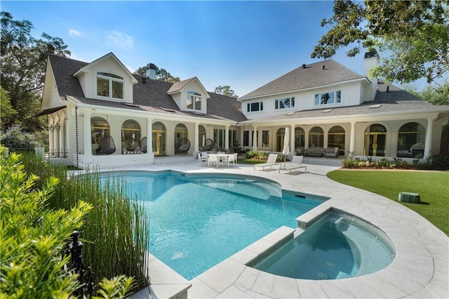 139 Fontainbleau Dr, Mandeville, LA 70471 - back of property featuring a patio, a pool with connected hot tub, a chimney, a lawn, and roof with shingles