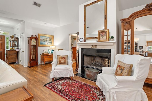 612 E 4th Ave, Covington, LA 70433 - living area featuring a tiled fireplace, wood finished floors, healthy amount of natural light, crown molding, and baseboards