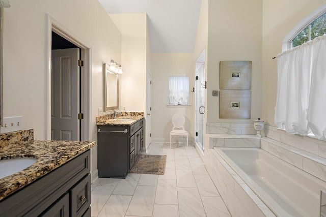 612 E 4th Ave, Covington, LA 70433 - bathroom with a shower stall, two vanities, marble look tile flooring, a bath, and baseboards