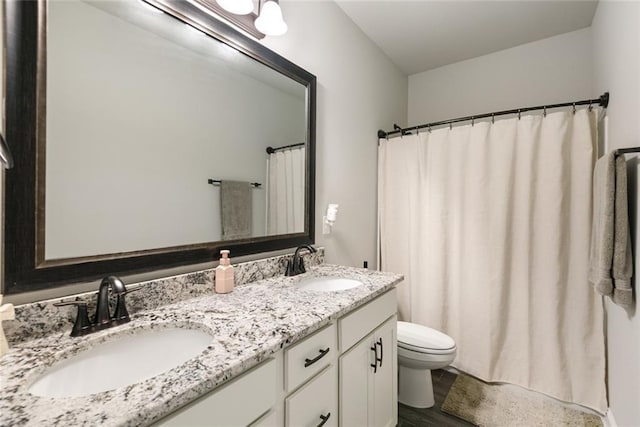 6476 Nesting Dr, Gonzales, LA 70737 - bathroom featuring toilet, double vanity, and wood finished floors