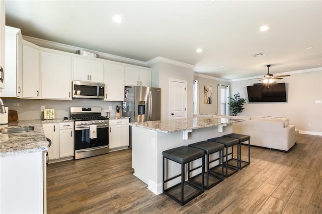6476 Nesting Dr, Gonzales, LA 70737 - kitchen with appliances with stainless steel finishes, ornamental molding, open floor plan, a center island, and recessed lighting
