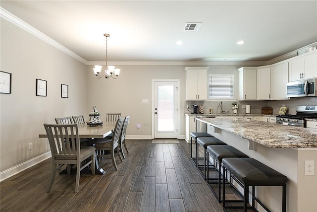 6476 Nesting Dr, Gonzales, LA 70737 - dining area with a chandelier, dark wood-type flooring, baseboards, crown molding, and recessed lighting