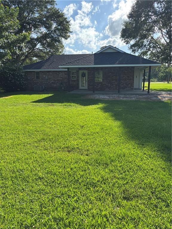 11036 Gulino Rd, Amite, LA 70422 - back of house featuring stone siding, a lawn, central AC, and a shingled roof