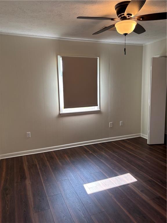11036 Gulino Rd, Amite, LA 70422 - spare room with crown molding, wood finished floors, a ceiling fan, baseboards, and a textured ceiling