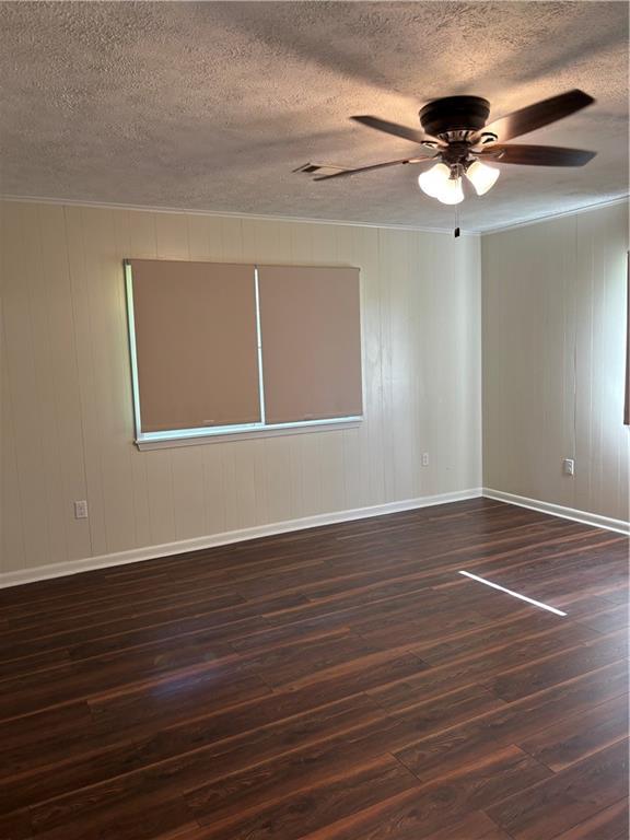 11036 Gulino Rd, Amite, LA 70422 - empty room with hardwood / wood-style flooring, a textured ceiling, ceiling fan, baseboards, and ornamental molding