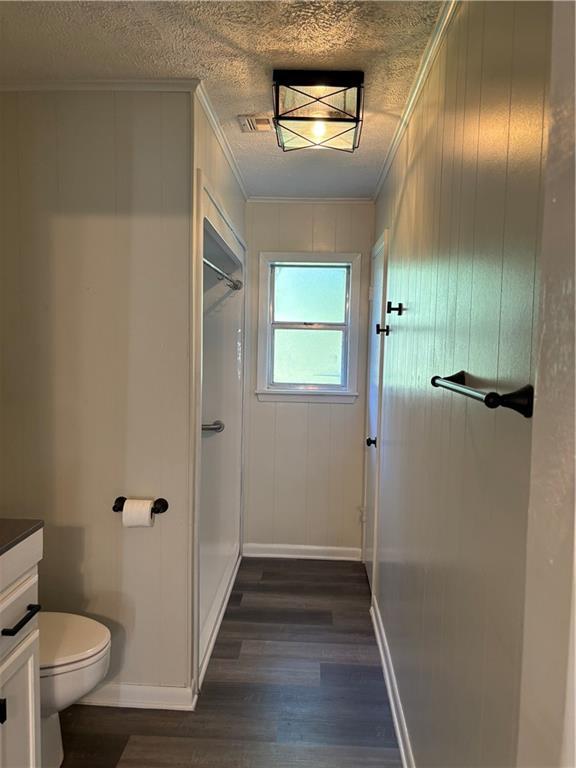 11036 Gulino Rd, Amite, LA 70422 - bathroom featuring vanity, wood finished floors, a shower, toilet, and baseboards