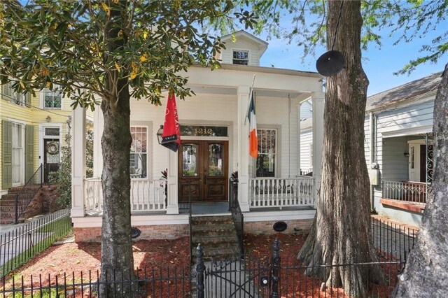 1212 Milan St, New Orleans, LA 70115 - view of front of home with a porch, french doors, a fenced front yard, and a gate
