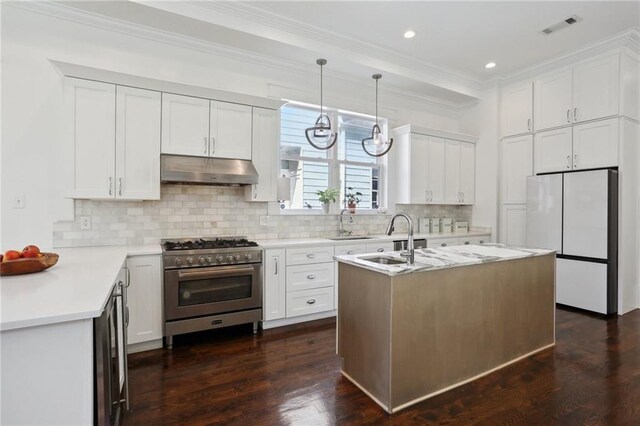 1212 Milan St, New Orleans, LA 70115 - kitchen with high end stainless steel range oven, under cabinet range hood, freestanding refrigerator, a sink, and crown molding