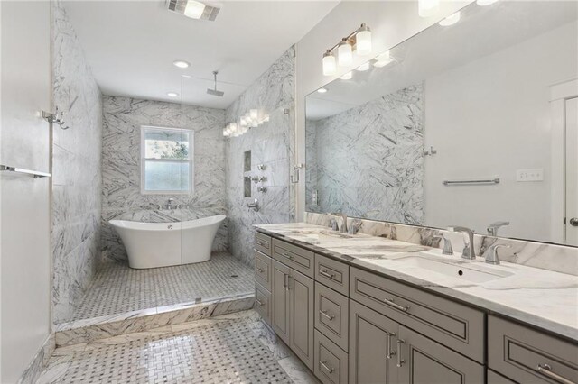 1212 Milan St, New Orleans, LA 70115 - full bathroom with double vanity, a freestanding tub, a marble finish shower, and tile walls