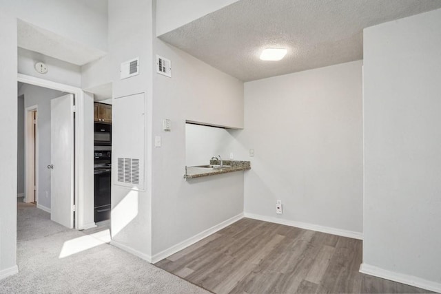 4218 Hessmer Ave Unit 309, Metairie, LA 70002 - spare room featuring a textured ceiling, baseboards, a smoke detector, wood finished floors, and bar area