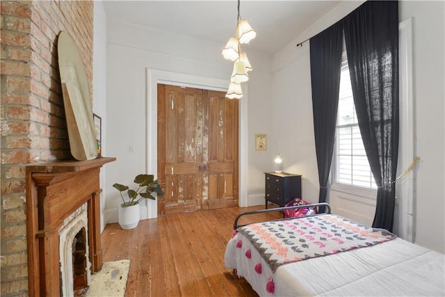 210911 Josephine St, New Orleans, LA 70113 - bedroom with hardwood / wood-style flooring, baseboards, vaulted ceiling, and a brick fireplace