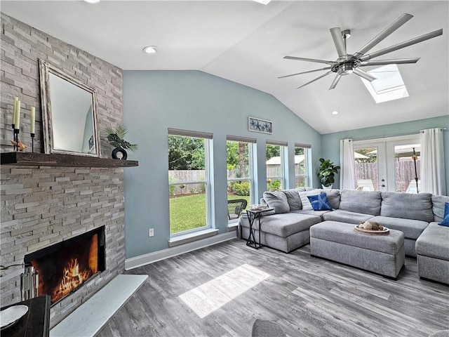 121 Matthews Dr, Slidell, LA 70458 - living area with a skylight, ceiling fan, vaulted ceiling, a large fireplace, and wood finished floors
