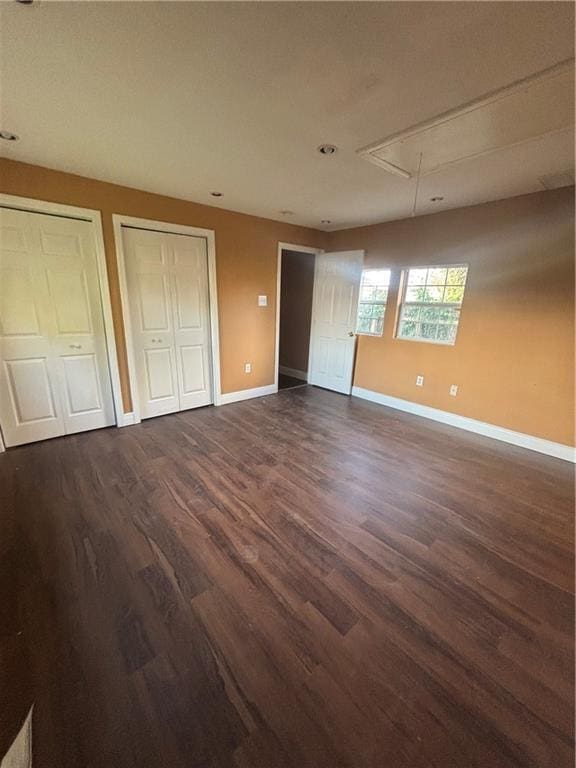 2428 Hamilton St, New Orleans, LA 70118 - unfurnished bedroom featuring attic access, two closets, dark wood finished floors, and baseboards