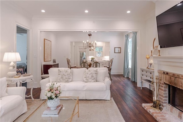 1302 W 23rd Ave, Covington, LA 70433 - living room with a chandelier, dark wood-style floors, a fireplace, ornamental molding, and recessed lighting