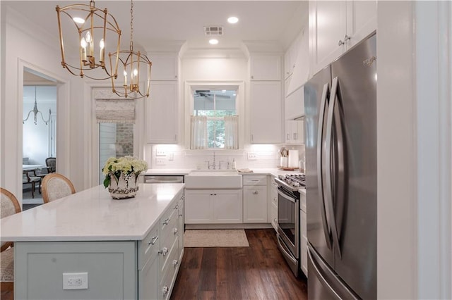 1302 W 23rd Ave, Covington, LA 70433 - kitchen featuring appliances with stainless steel finishes, a sink, a chandelier, white cabinets, and crown molding