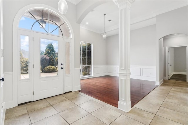 322 Palermo Dr, Slidell, LA 70458 - entrance foyer with light tile patterned flooring, ornate columns, arched walkways, wainscoting, and ornamental molding