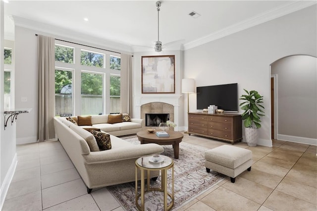 322 Palermo Dr, Slidell, LA 70458 - living room featuring ornamental molding, light tile patterned floors, a tiled fireplace, arched walkways, and ceiling fan