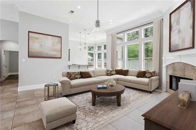 322 Palermo Dr, Slidell, LA 70458 - living area featuring a ceiling fan, light tile patterned flooring, crown molding, a tiled fireplace, and arched walkways