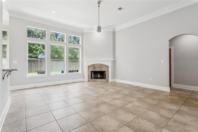 322 Palermo Dr, Slidell, LA 70458 - unfurnished living room featuring crown molding, light tile patterned floors, ceiling fan, arched walkways, and a tiled fireplace