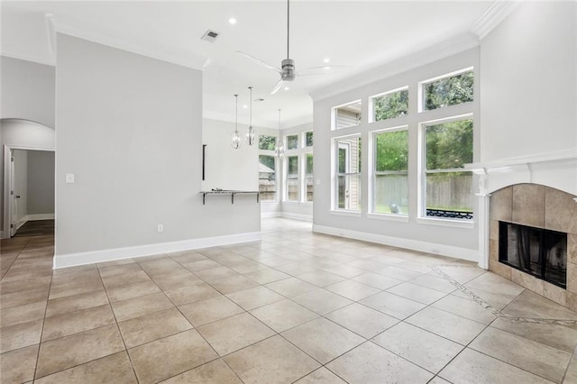 322 Palermo Dr, Slidell, LA 70458 - unfurnished living room featuring ceiling fan, crown molding, light tile patterned floors, a tiled fireplace, and arched walkways