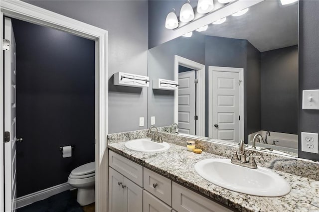 19499 Deerfield Loop, Loranger, LA 70446 - bathroom featuring double vanity, toilet, a bath, and baseboards