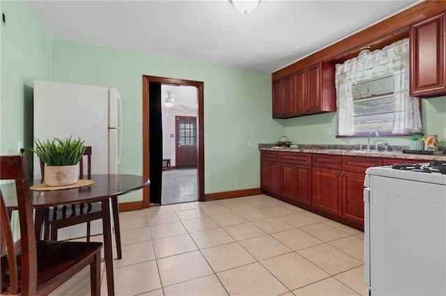 230 Jules Ave, Jefferson, LA 70121 - kitchen featuring gas stove, freestanding refrigerator, dark brown cabinets, a sink, and light tile patterned flooring