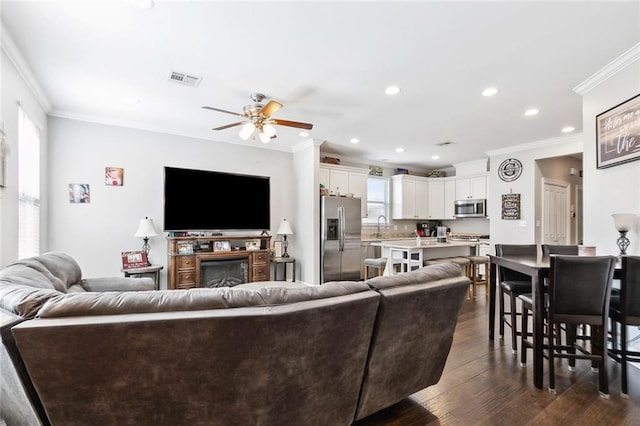 1233 Brockenbraugh Ct, Metairie, LA 70005 - living room featuring crown molding, ceiling fan, dark wood-style flooring, recessed lighting, and a fireplace