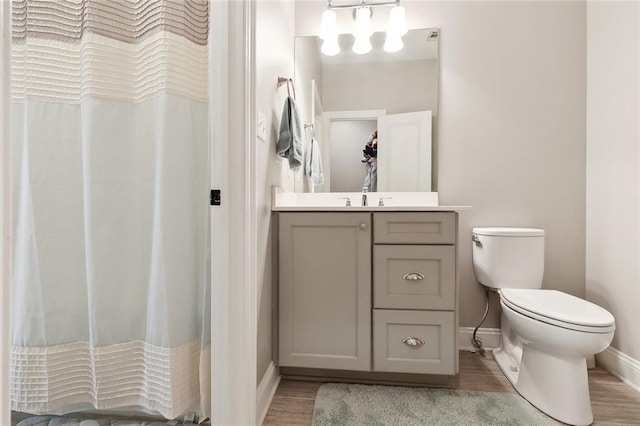 1233 Brockenbraugh Ct, Metairie, LA 70005 - bathroom featuring baseboards, vanity, toilet, wood finished floors, and a shower with curtain