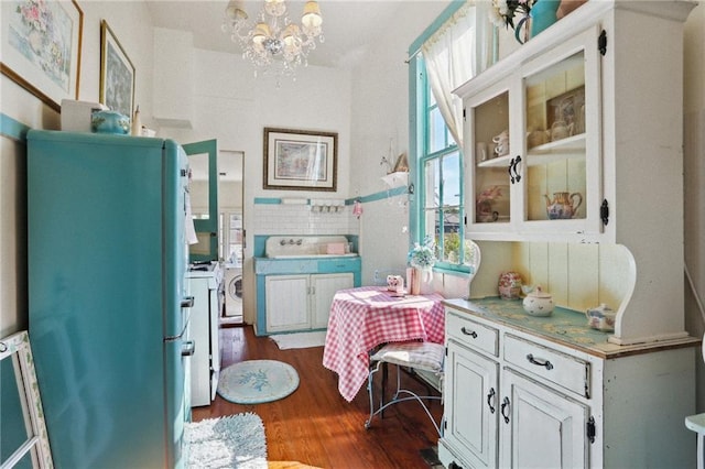 4501 Canal St, New Orleans, LA 70119 - interior space featuring washing machine and clothes dryer, dark wood-style flooring, and a chandelier