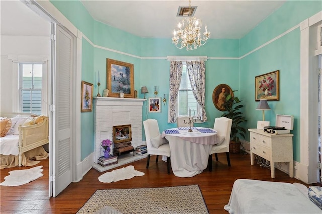 4501 Canal St, New Orleans, LA 70119 - dining space with a chandelier, dark wood-style flooring, and a brick fireplace