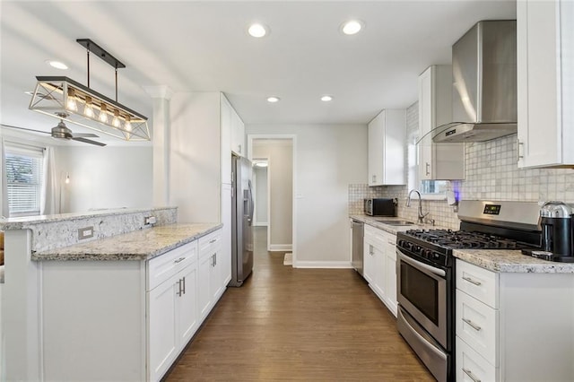 4009 Purdue Dr, Metairie, LA 70003 - kitchen with appliances with stainless steel finishes, wall chimney exhaust hood, a sink, tasteful backsplash, and baseboards