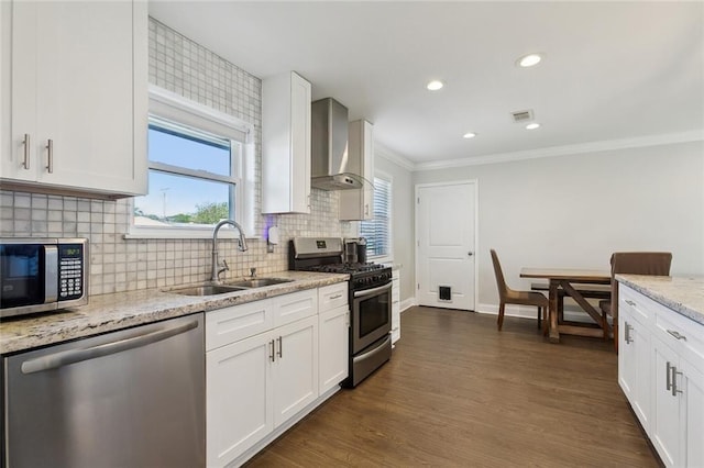 4009 Purdue Dr, Metairie, LA 70003 - kitchen featuring stainless steel appliances, wall chimney exhaust hood, a sink, white cabinets, and ornamental molding