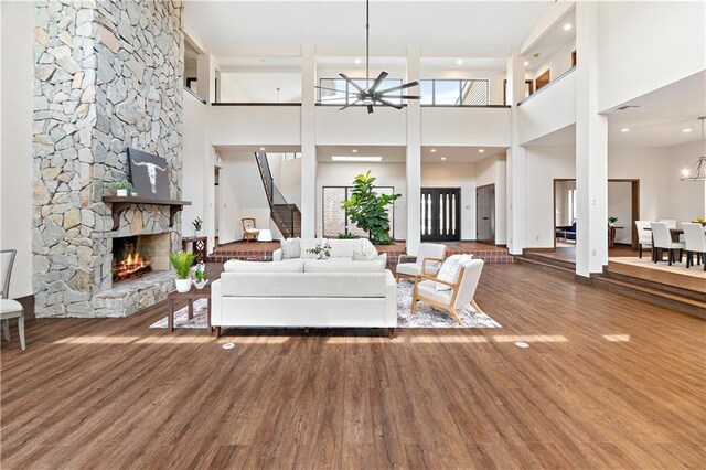 73 Doescher Dr, Harahan, LA 70123 - living room featuring ceiling fan, a stone fireplace, a high ceiling, and wood finished floors