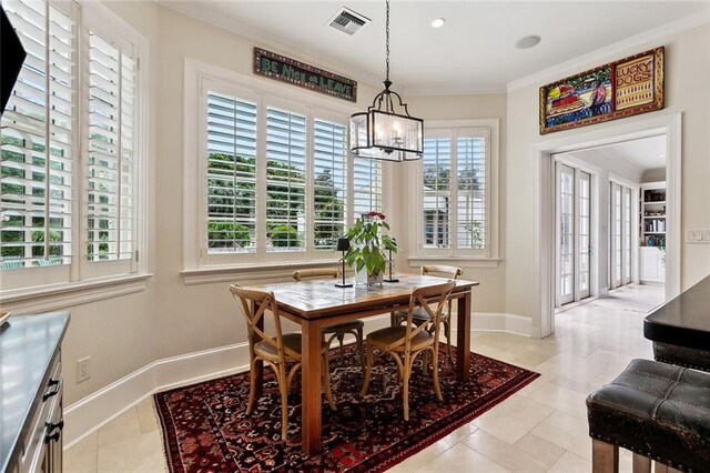 105 Mulberry Dr, Metairie, LA 70005 - dining area featuring a chandelier, ornamental molding, baseboards, and light tile patterned flooring