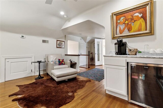105 Mulberry Dr, Metairie, LA 70005 - living room with wine cooler, vaulted ceiling, wood finished floors, a bar, and a ceiling fan